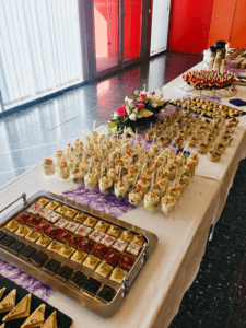 Buffet traiteur avec verrines, mignardises et assortiments de petits fours, idéal pour des réceptions et événements dans la région de Savenay, mis en scène avec une décoration florale