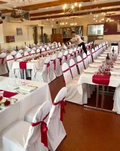 Salle décorée pour un mariage au Royam, avec tables élégamment dressées et ambiance chaleureuse, parfaite pour célébrer des événements uniques.