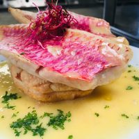 Tatin de rouget avec sauce aux herbes, une spécialité raffinée du Royam pour les amateurs de poisson