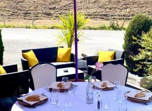 Déjeuner en extérieur avec tables dressées et vue sur la terrasse, offrant un cadre accueillant pour un repas convivial organisé par le Royam